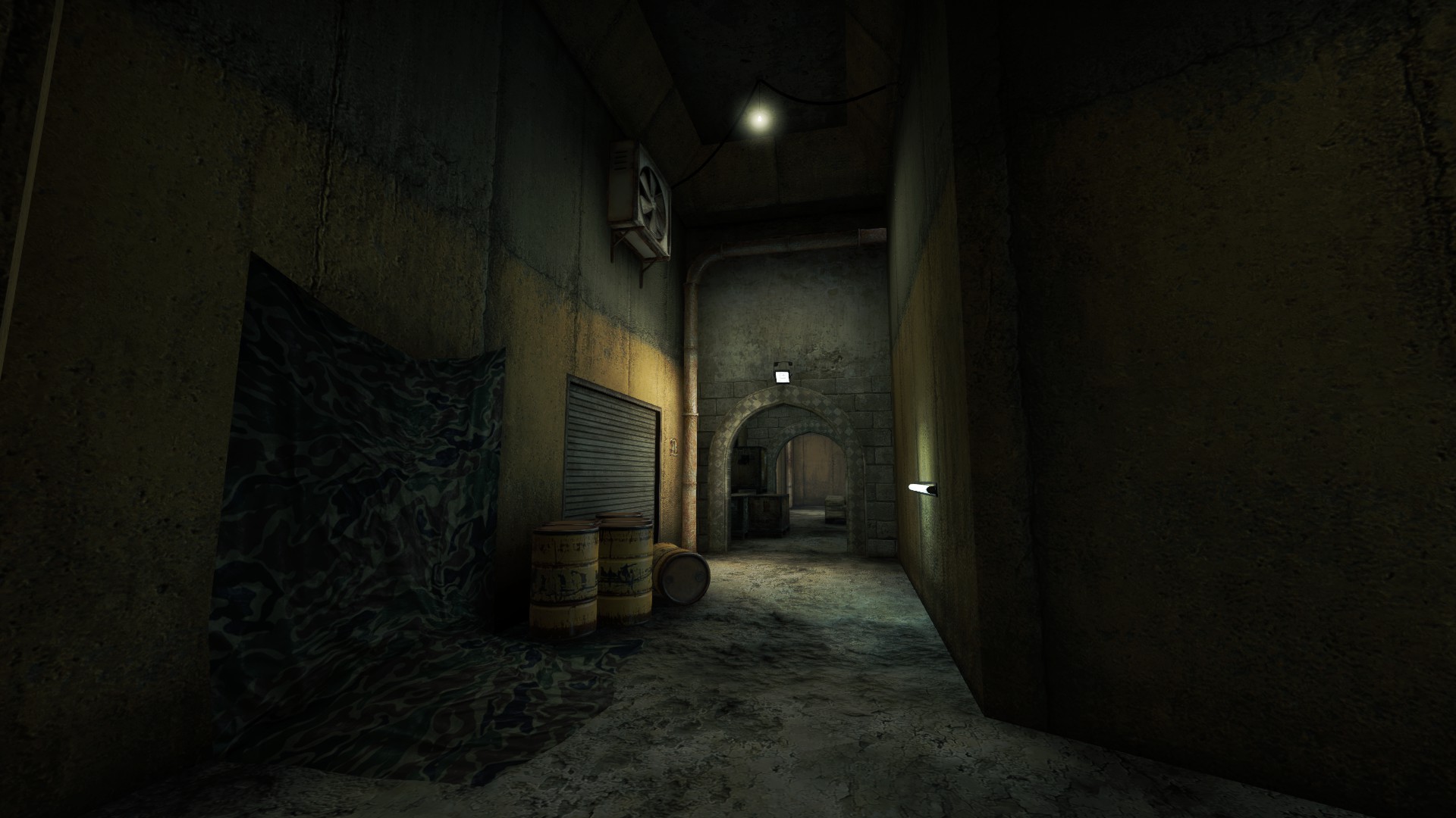 Dark interior alley with oil barrels, a camo tarp and a single hanging bulb