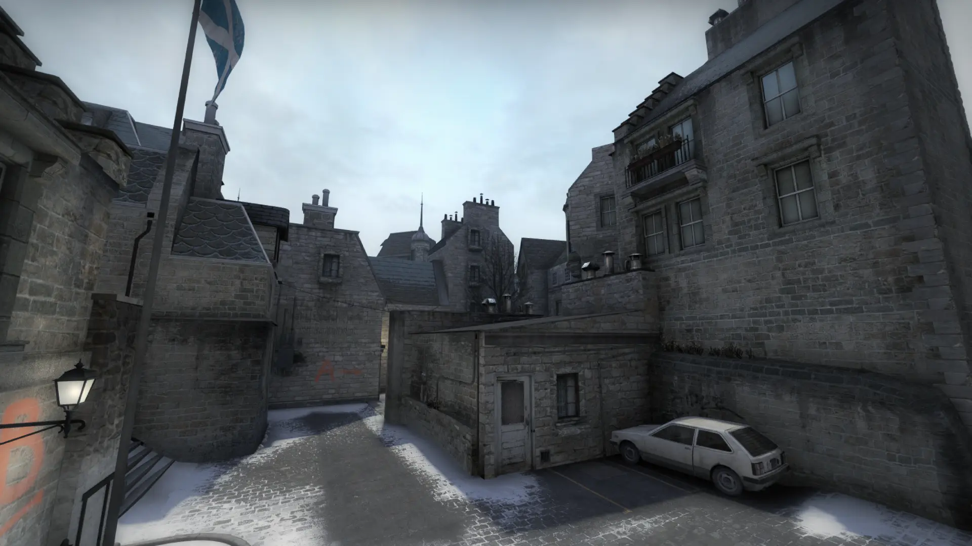 Snowy courtyard with a stone wall, a parked car and a Scottish flag