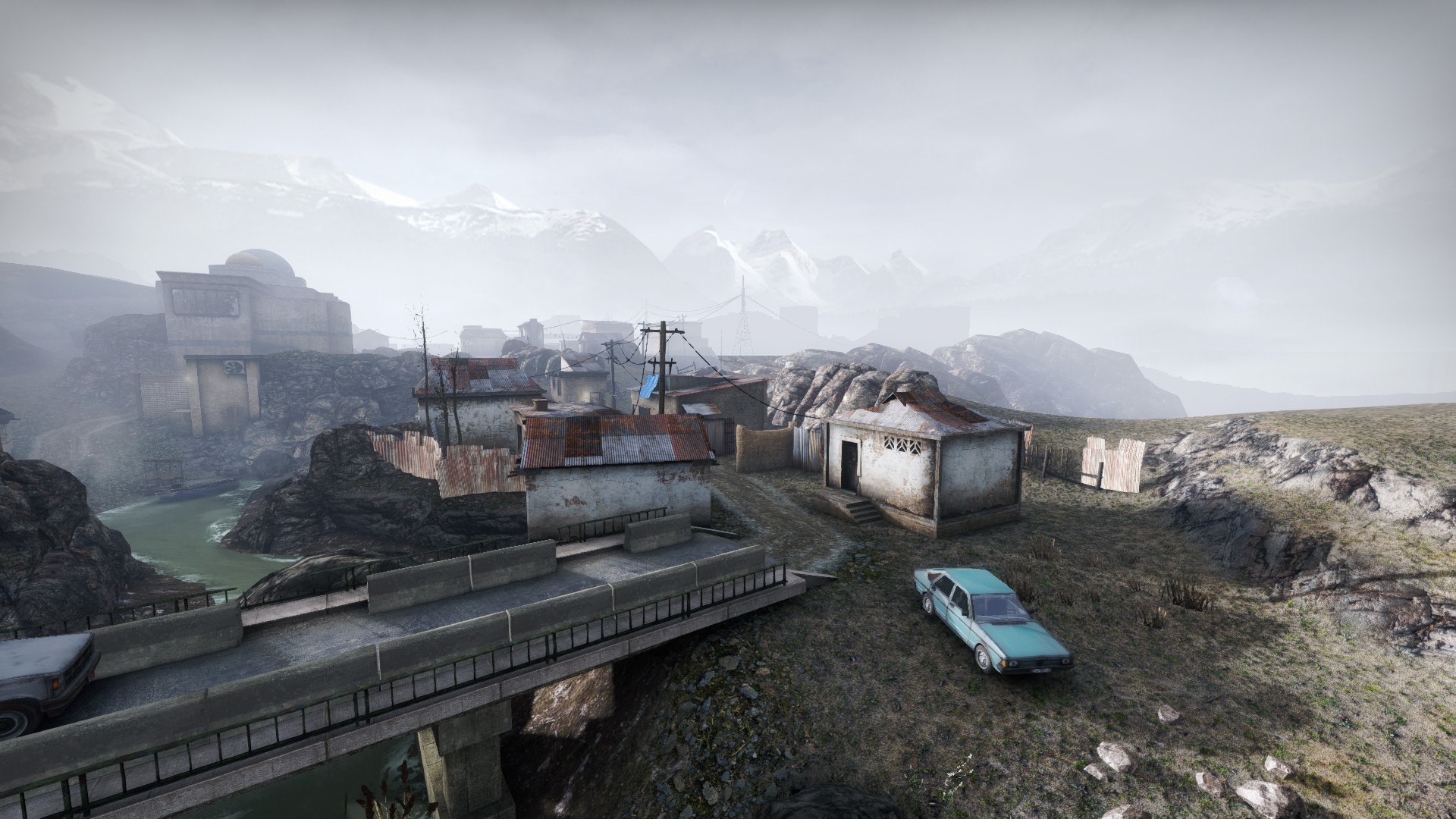 Concrete bridge crossing the river with a parked car and mountains in the mist